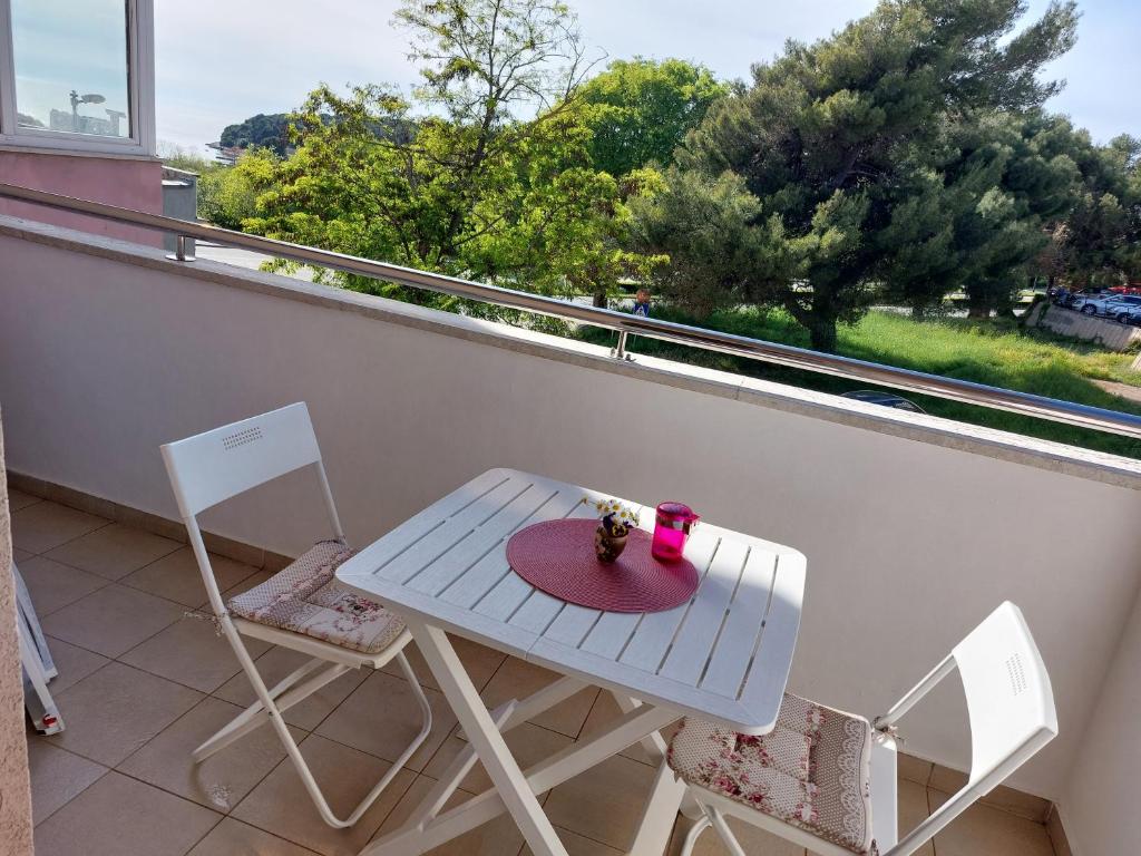 a white table and two chairs on a balcony at Apartman Suzy in Pula