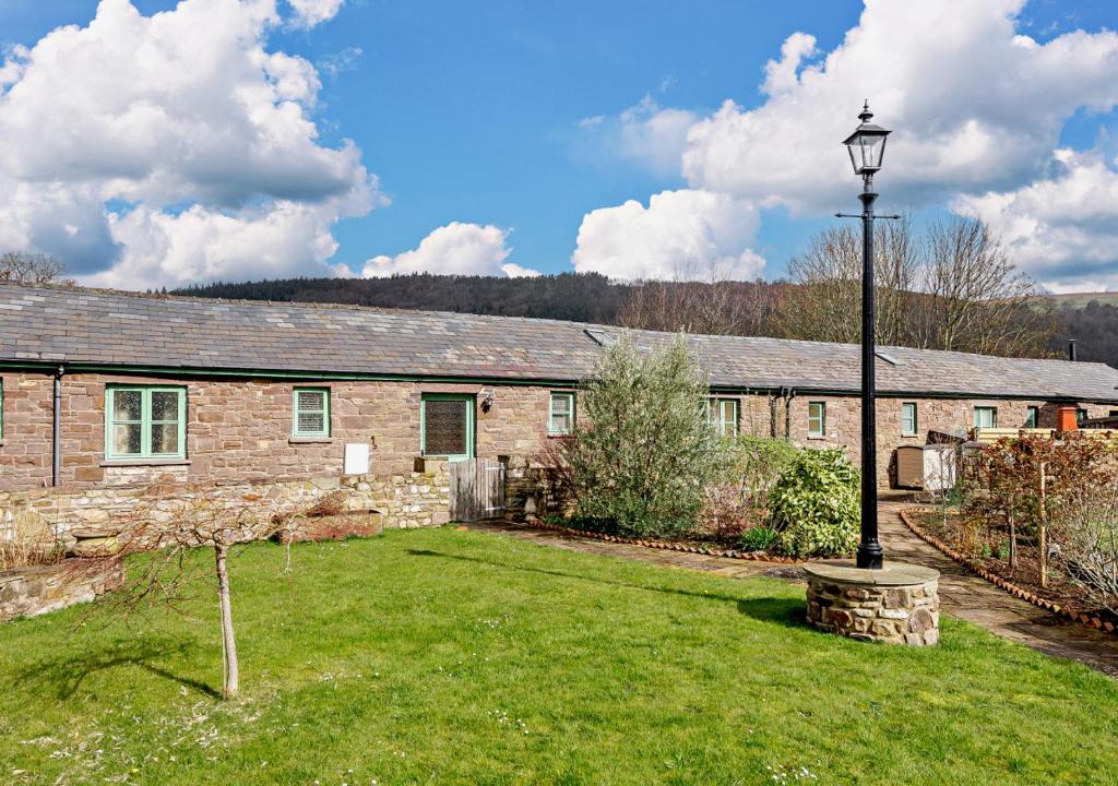 a brick house with a lamp in the yard at Orchard View in Gilwern