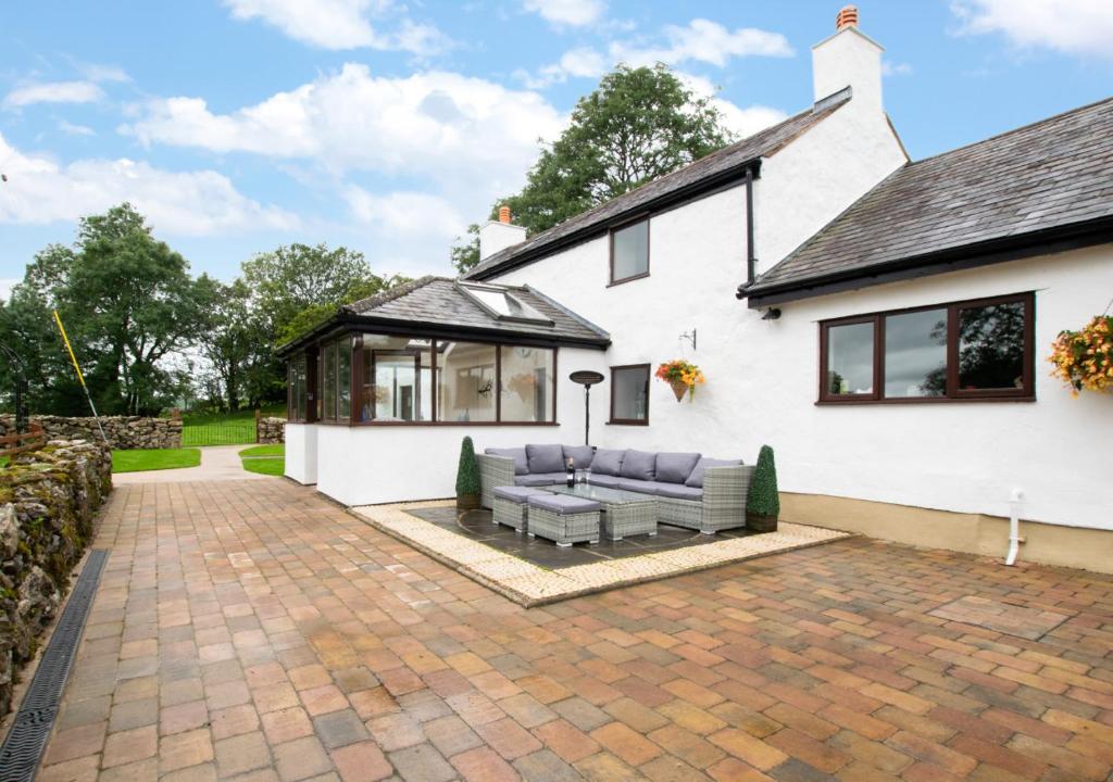 a white house with a patio with a couch at Top Y Nant in Mold