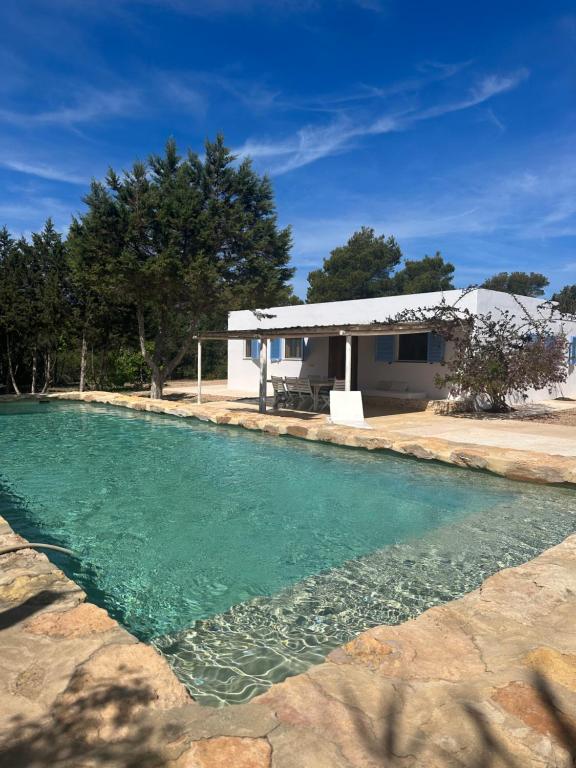 una piscina de agua frente a una casa en Casa Mayo, en Sant Francesc Xavier