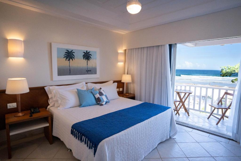 a bedroom with a bed with a view of the ocean at Maravista Hotel & Spa Ltda in Búzios