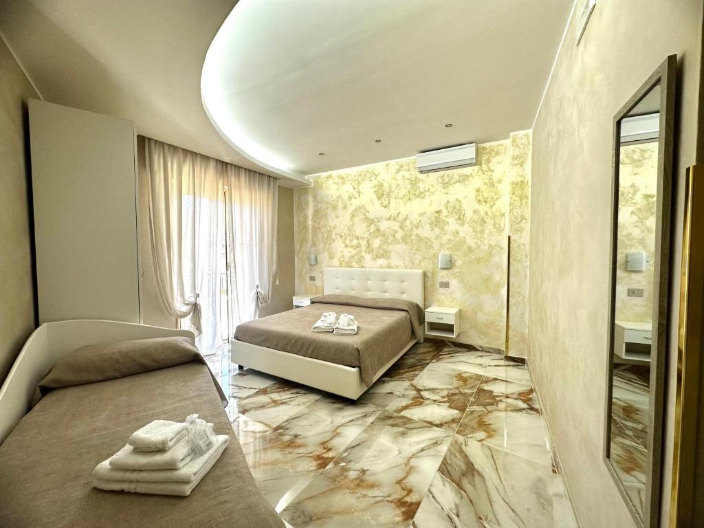 a bedroom with two beds and a marble floor at B&B Narcisse in Tropea