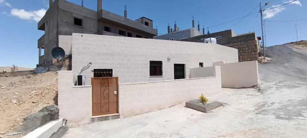 un edificio blanco con una puerta a un lado en Asem Studio apartment, en Wadi Musa