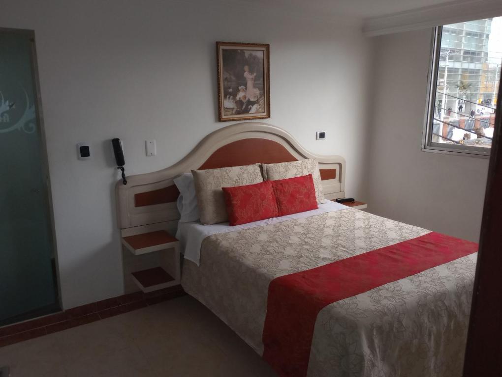 Hotel Zulita في بوغوتا: غرفة نوم بسرير كبير ومخدات حمراء