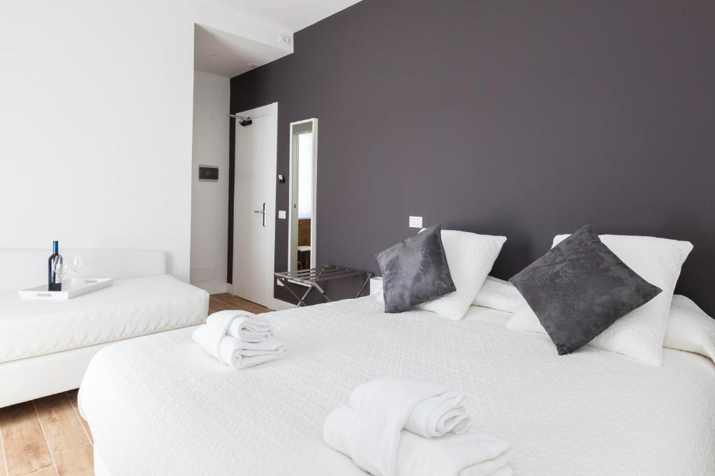ローマにあるカサ 901のバスルーム付きの客室で、白いベッド2台が備わります。