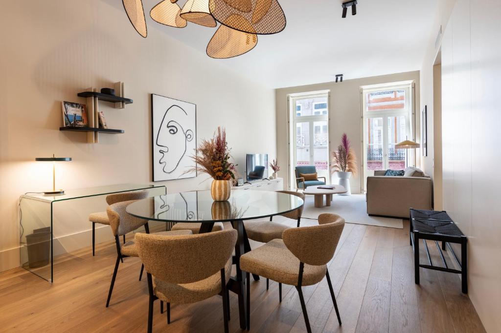 uma sala de estar com uma mesa de vidro e cadeiras em Ando Living - Santa Catarina Townhouse no Porto