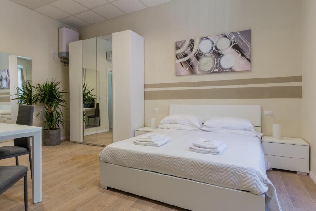 a bedroom with a bed and a table and a mirror at Center Rooms in Piacenza