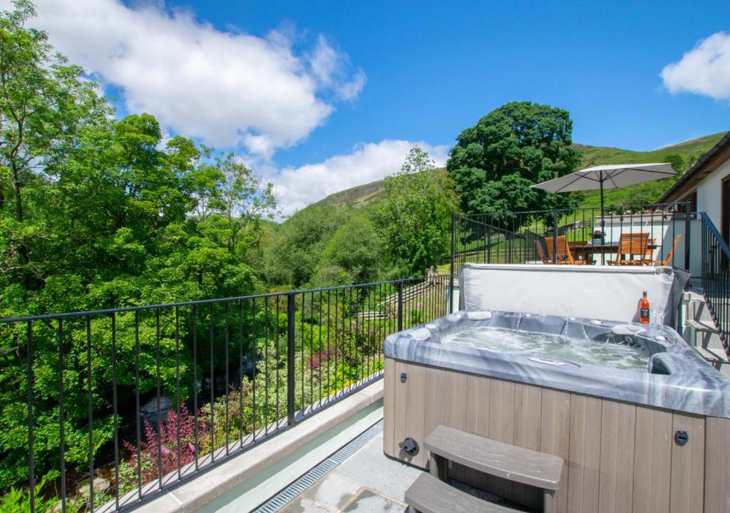 a hot tub on the balcony of a house at Ystabl y Berwyn in Llanarmon Dyffryn-Ceiriog