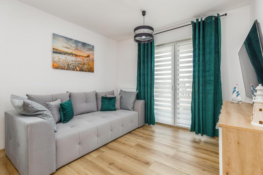隱海市的住宿－Pet friendly Apartment Górna 31 by Renters，客厅配有白色沙发和绿色窗帘