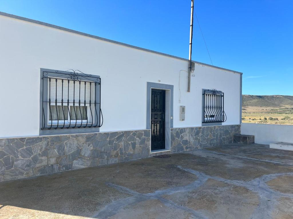 un edificio bianco con una porta e una finestra di CORTIJO DEL LUCERO, FERNAN PEREZ a Almería