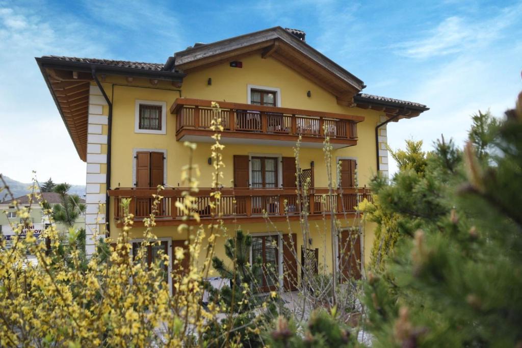 uma casa amarela com uma varanda em cima em RAINBOW em Rovereto