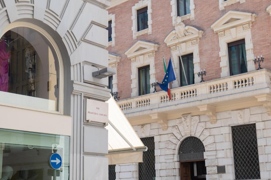 a building with a balcony and a flag on it at Relais Palazzo Olimpia - Corso Vittorio Emanuele in Salerno