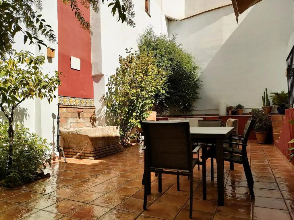 ein Tisch und Stühle in einem Innenhof mit Pflanzen in der Unterkunft Dar Ar Nur Albaycin con patio in Granada