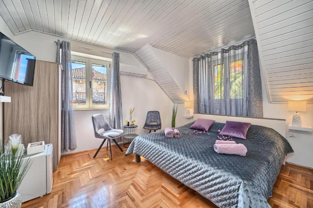 Un dormitorio con una cama con almohadas moradas. en Couple's Getaway in the Center of Hvar w/Sea View en Hvar