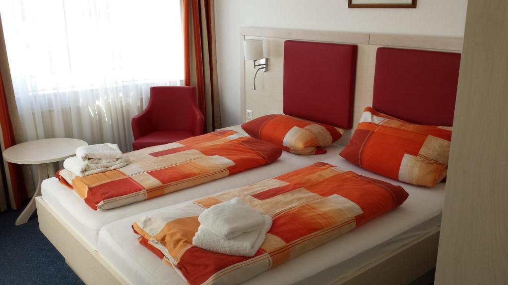 a hotel room with two beds with towels on them at Hotel & Restaurant Möwchen in Norden