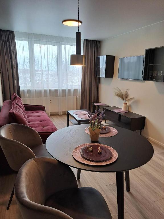 a living room with a table and chairs at Naujai įrengtas jaukus dviejų kambarių butas in Šiauliai