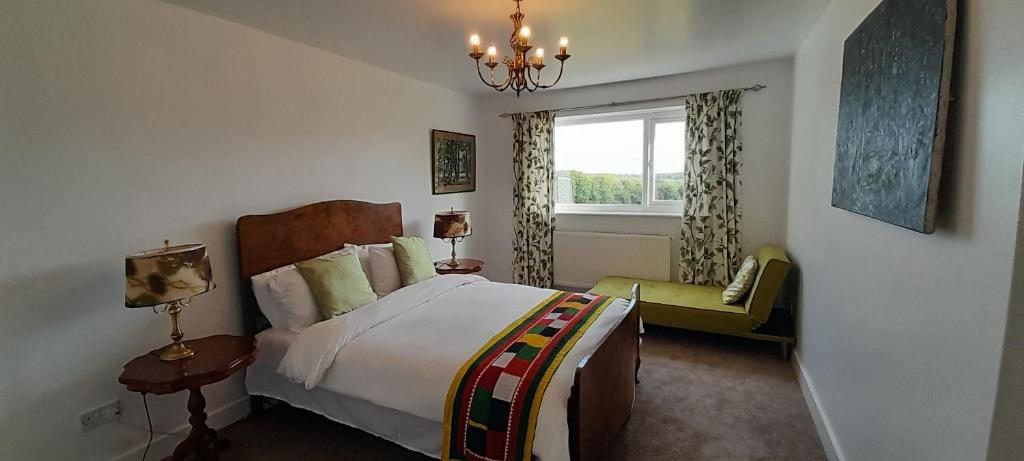 a bedroom with a large bed and a window at Fox Meadow Peacehaven Farm in Battle