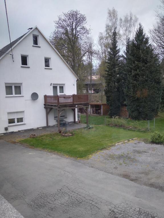 une maison blanche avec une terrasse et une cour dans l'établissement Haus Peter, à Eppendorf