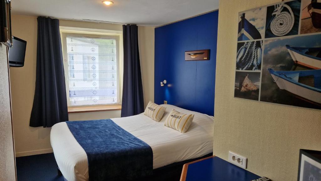 a hotel room with a bed and a window at Hotel Le Marin in Auray