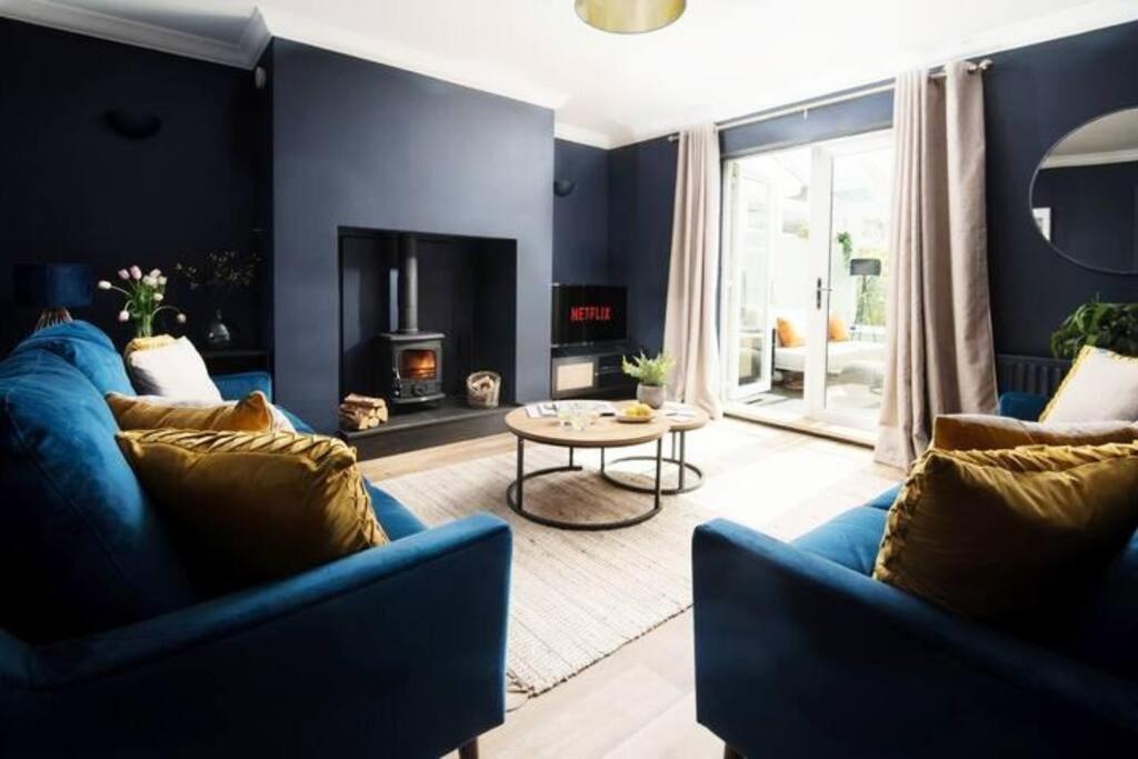 アニックにあるBeautiful 5 Bedroom House - Alnwickのリビングルーム(青いソファ2台、暖炉付)