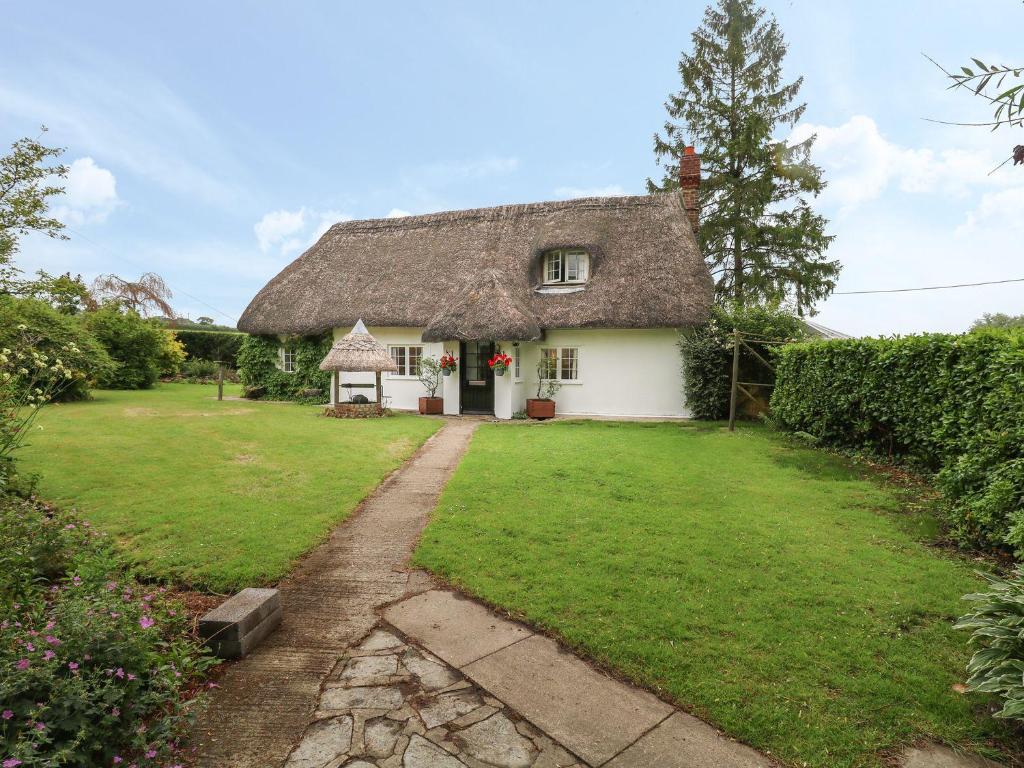 a thatched cottage with a path leading to it at Thatch Cottage in Dorchester