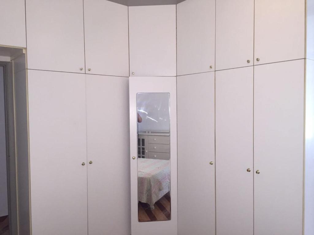 Habitación con armarios blancos y cama con espejo. en Espaço Copacabana Comfort Two Bedrooms - Alugue o apartamento inteiro, en Río de Janeiro