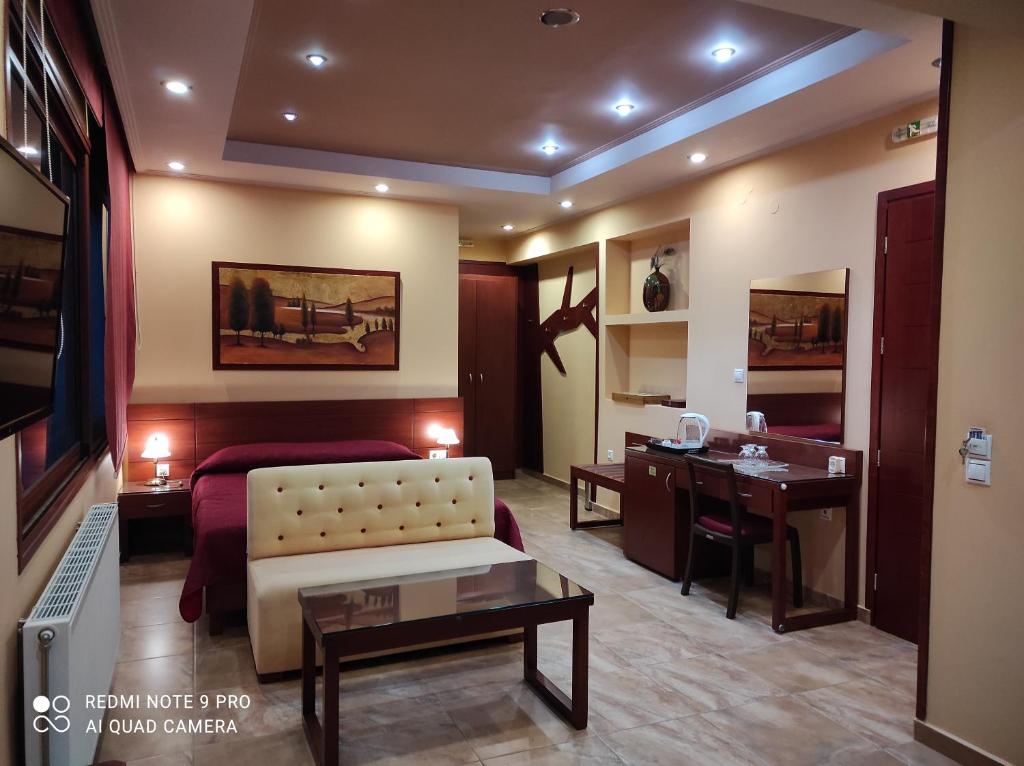Villa Koulouridi في ذاراتسو: غرفة معيشة مع سرير ومكتب في غرفة