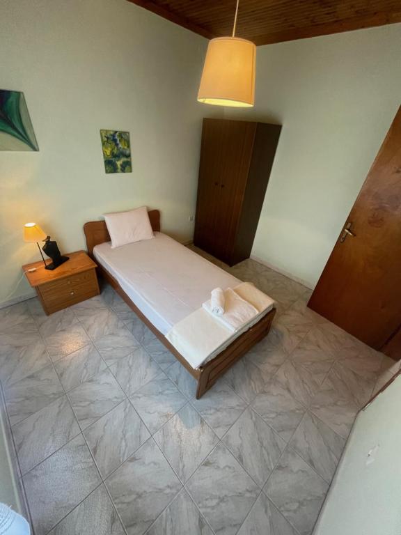 um pequeno quarto com uma cama e um candeeiro em Hοme4U em Kallikrateia