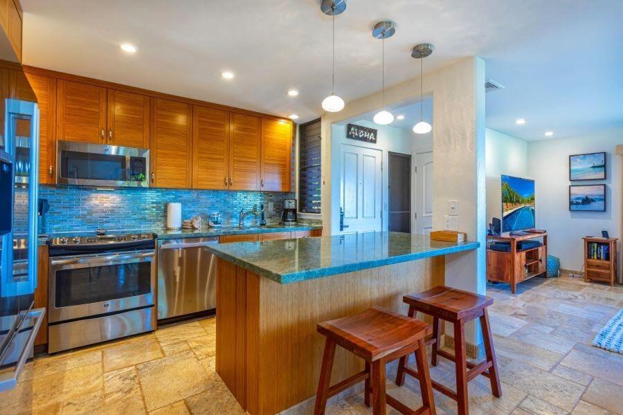 cocina grande con encimera y 2 taburetes en WAILEA ELUA, #0305 condo, en Wailea