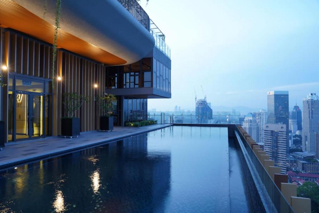een zwembad bovenop een gebouw met een stad bij Ceylonz Suites KL City by One39KL in Kuala Lumpur