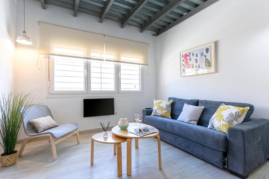 sala de estar con sofá azul y TV en Livemalaga Pedregalejo, en Málaga