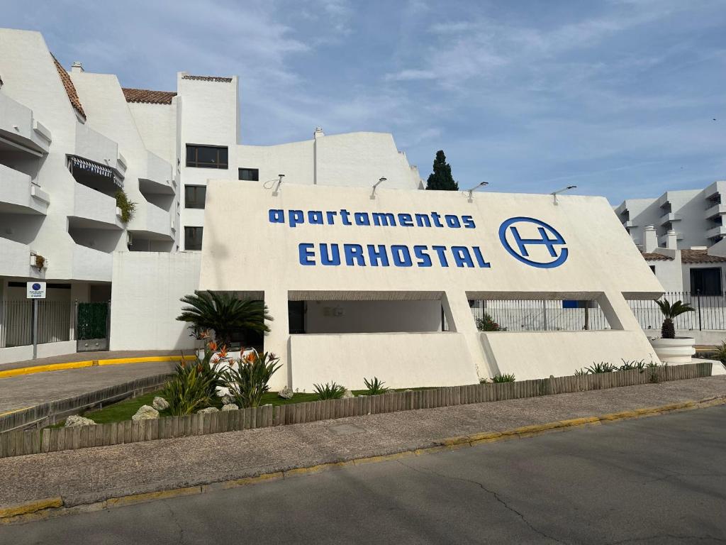 un bâtiment avec un panneau indiquant l'entrée d'un hôpital dans l'établissement APARTMENTOS EUROHOSTAL 1linea de playa las fuentes, à Alcossebre