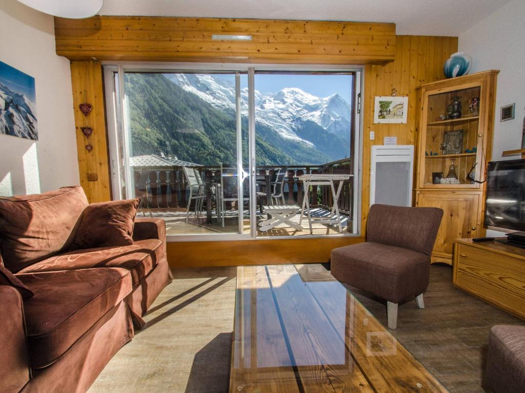 un salon avec un canapé et une grande fenêtre dans l'établissement Appartement à Chamonix avec terrasse, parking, local à skis - FR-1-343-172, à Chamonix-Mont-Blanc