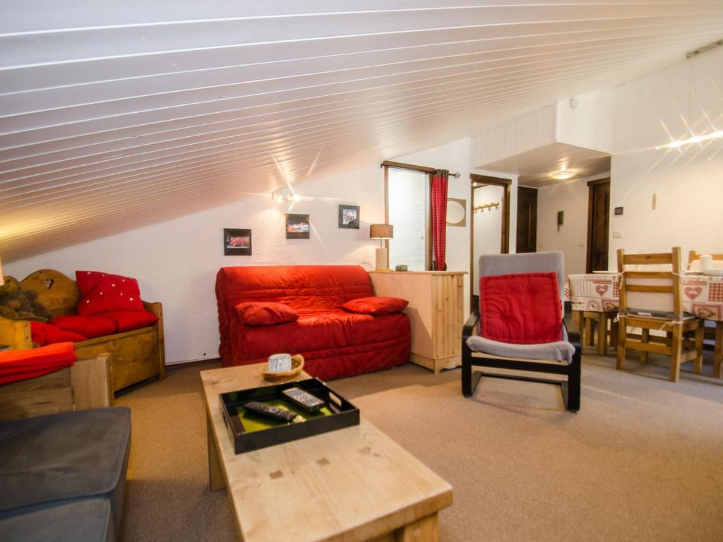 un salon avec un canapé rouge et une table dans l'établissement Charmant appartement avec balcon, parking et WiFi à Chamonix - FR-1-343-214, à Chamonix-Mont-Blanc