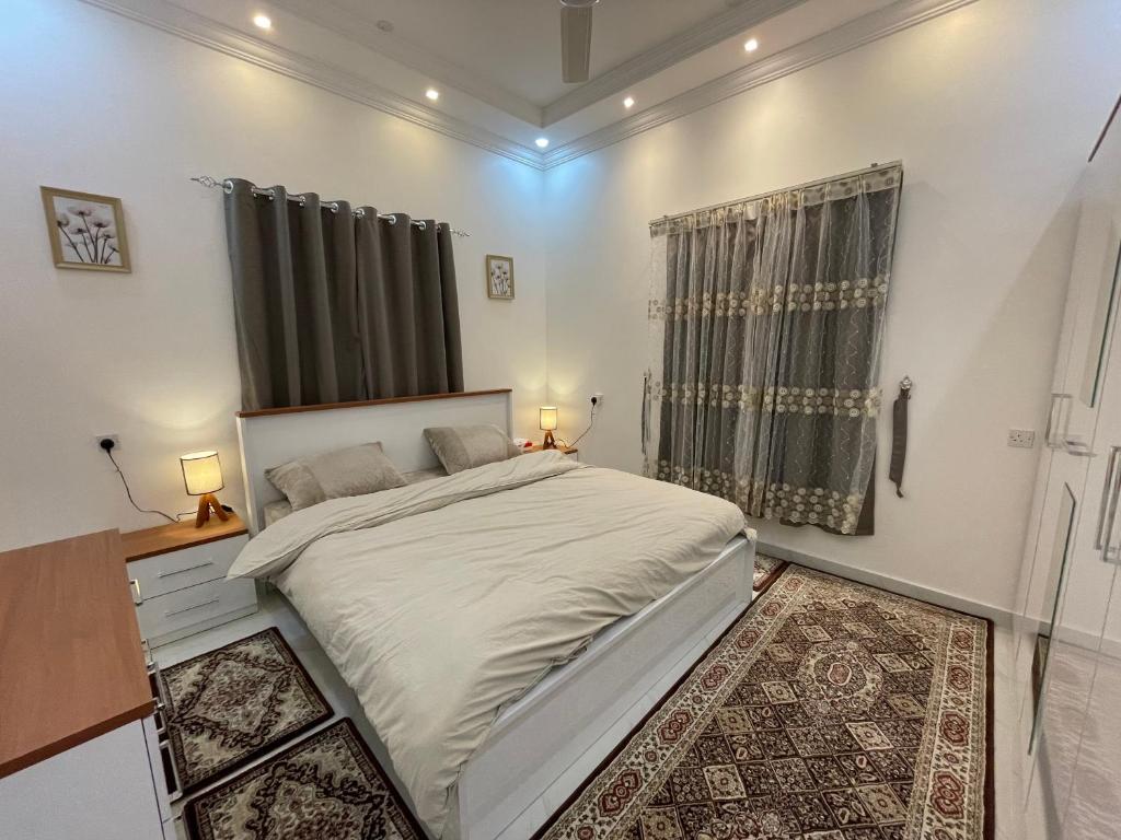 a bedroom with a large white bed and a window at Apartment in Bayt Al Jabal شقة في بيت الجبل in Sayq
