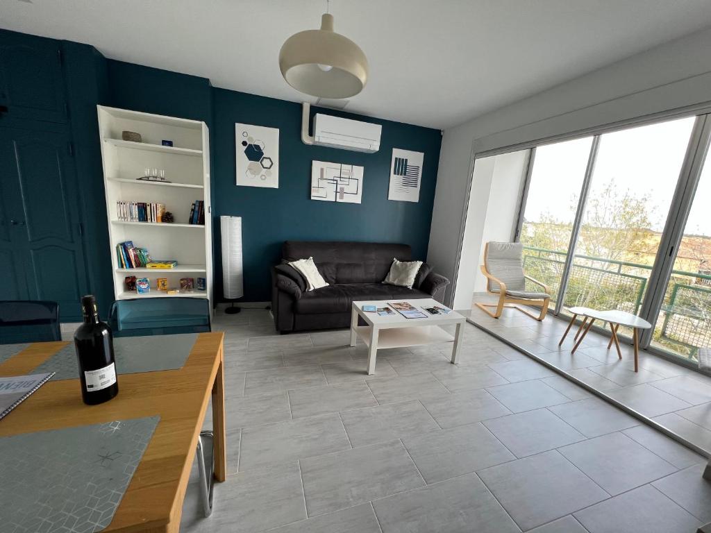 un salon avec un canapé et une table dans l'établissement Superbe appartement climatisé, 2 chambres à 200m de la plage, au Grau-du-Roi