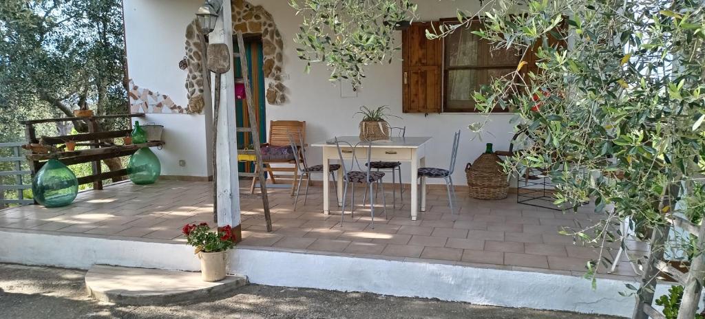 Villa Bruno في بيستيشي: منزل به طاولة وكراسي على الفناء