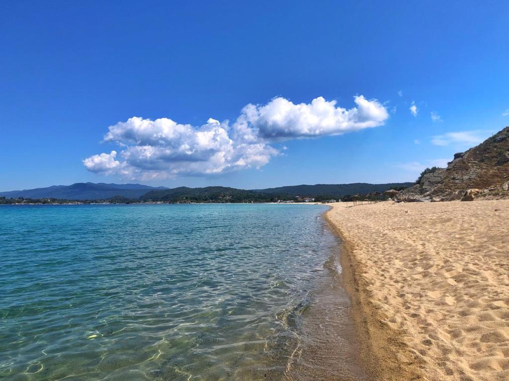 une plage avec l'eau et les montagnes en arrière-plan dans l'établissement Kritamo villa on Trani Ammouda beach, à Ágios Nikólaos