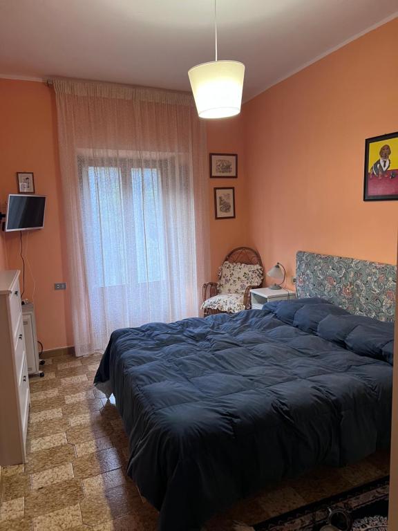 een slaapkamer met een blauw bed en een raam bij L'altro PAGLIUCO - Casa in Campagna in Sulmona