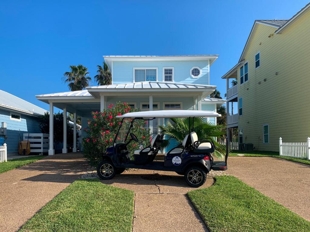 un carro de golf estacionado frente a una casa en FD115 Spacious Home in Royal Sands, Shared Pool & Hot Tub, Golf Cart Included, Beach Boardwalk en Port Aransas