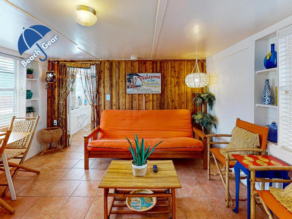 an orange couch in a living room with a table at NS731 Coastal Cottage, In Town Near Shops, Restaurants and Nightlife in Port Aransas