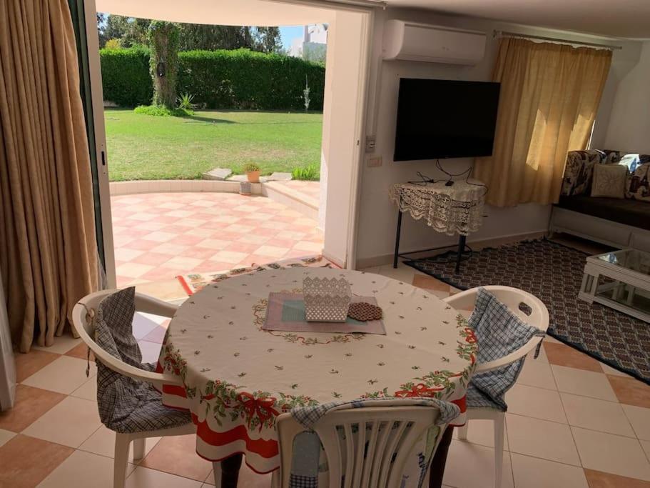 a table and chairs in a living room with a television at Pleasant house in Africa Jade 200m to the beach in Korba