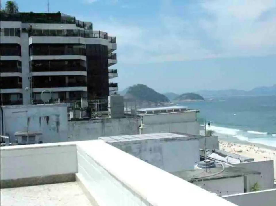 un edificio en la playa con el océano en el fondo en MARCOLINI - Cobertura Vista Mar na Praia de Copacabana en Río de Janeiro