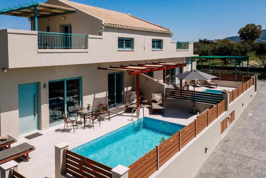 een villa met een zwembad en een huis bij Melior Holiday Houses in Laganas