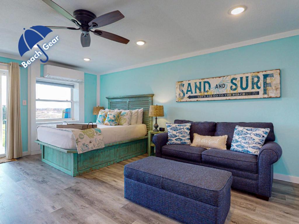 una camera con letto, divano e ventilatore di IR127 Sea Kissed, Boardwalk to the Beach, First Floor Studio Condo, Shared Pool a Port Aransas
