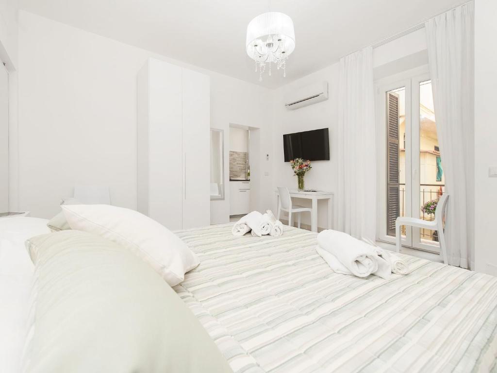 biała sypialnia z dużym łóżkiem z białymi poduszkami w obiekcie White Flat Termini w Rzymie