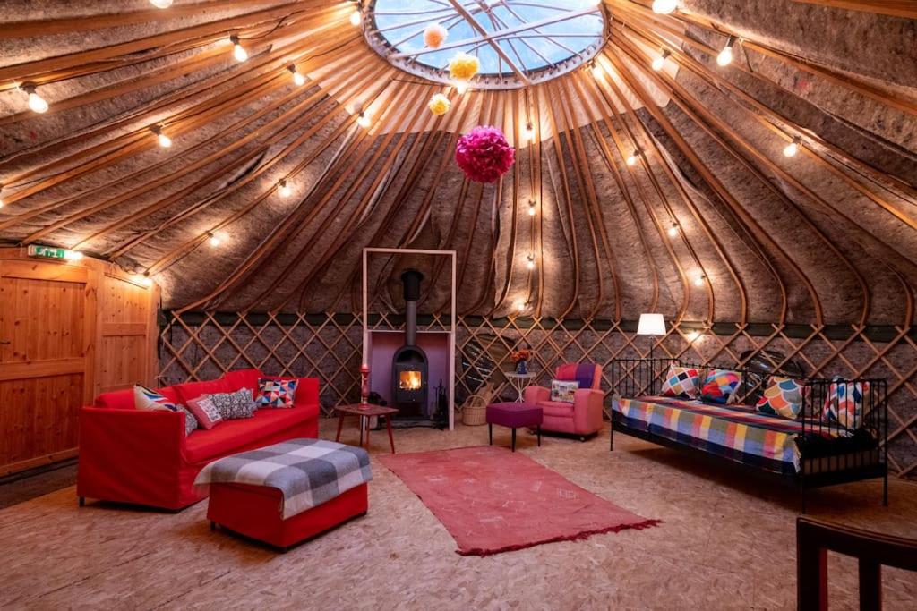una sala de estar con una habitación grande con techo de madera en Giant Yurt Sleeping 8 with Spa, Catering, Walled Gardens, Nature Reserve, Free Parking en Scunthorpe