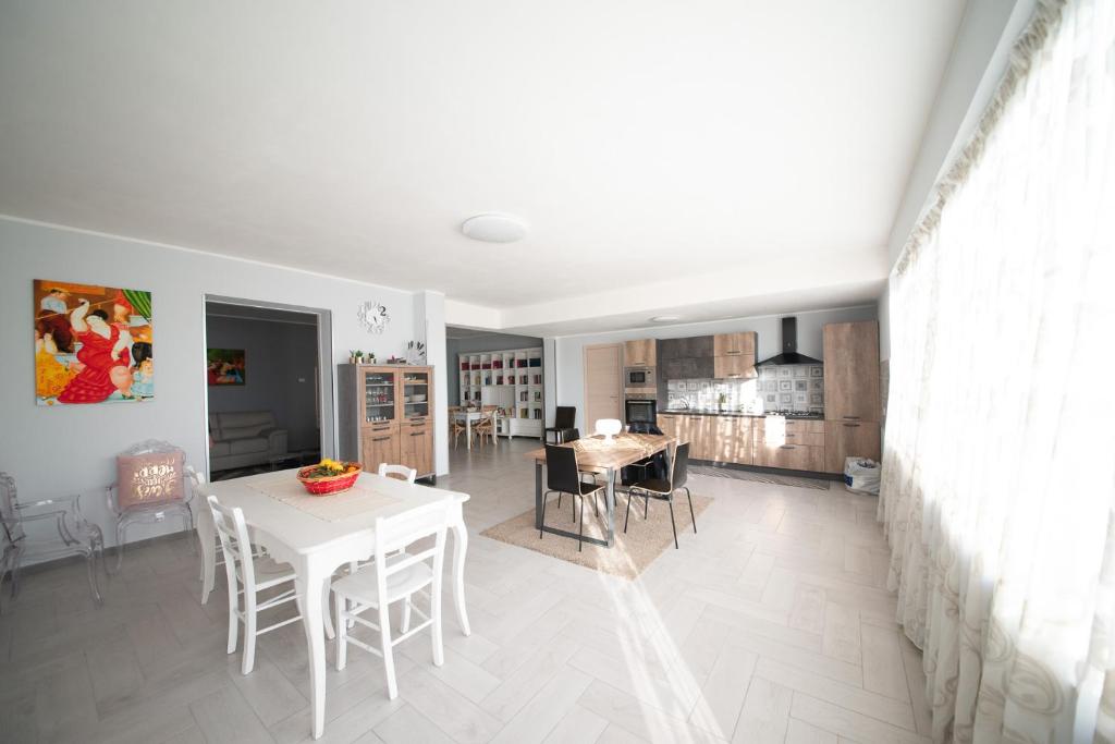 a kitchen and dining room with a white table and chairs at 10 e Lode in Mazara del Vallo