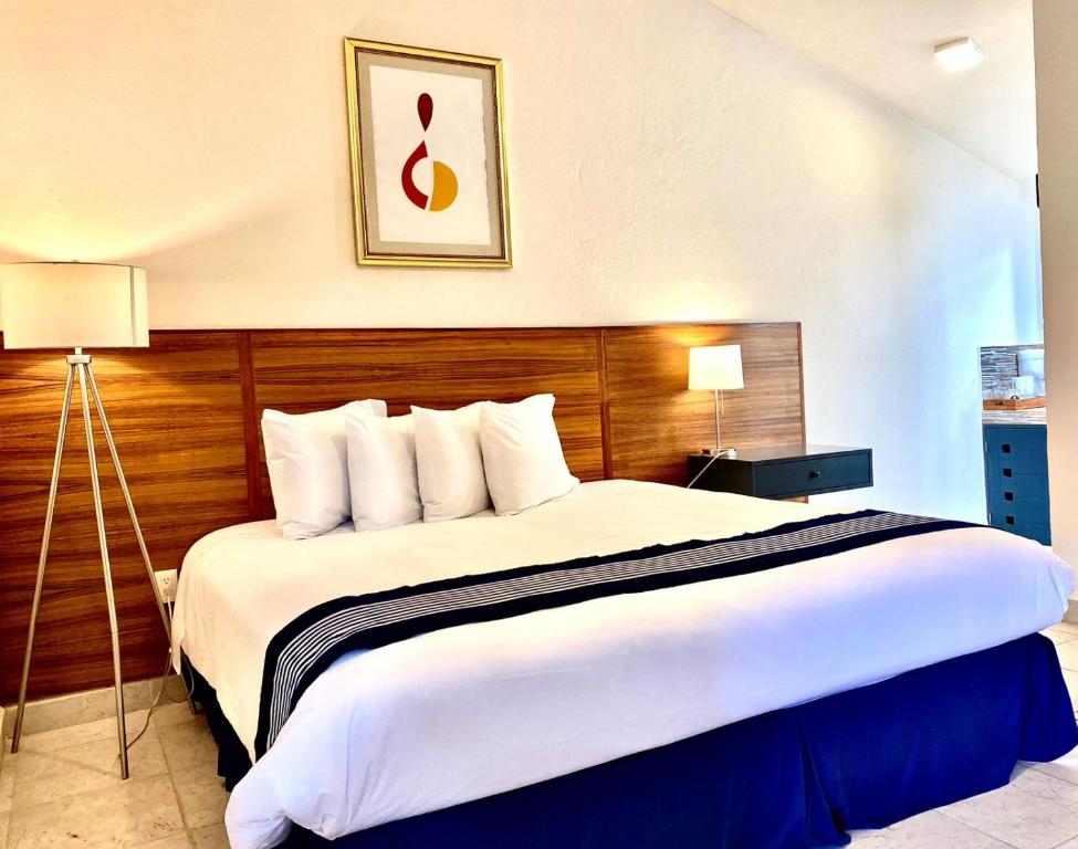 a hotel room with a large bed with white sheets at Arawi Hotel Boutique in Valle de Bravo