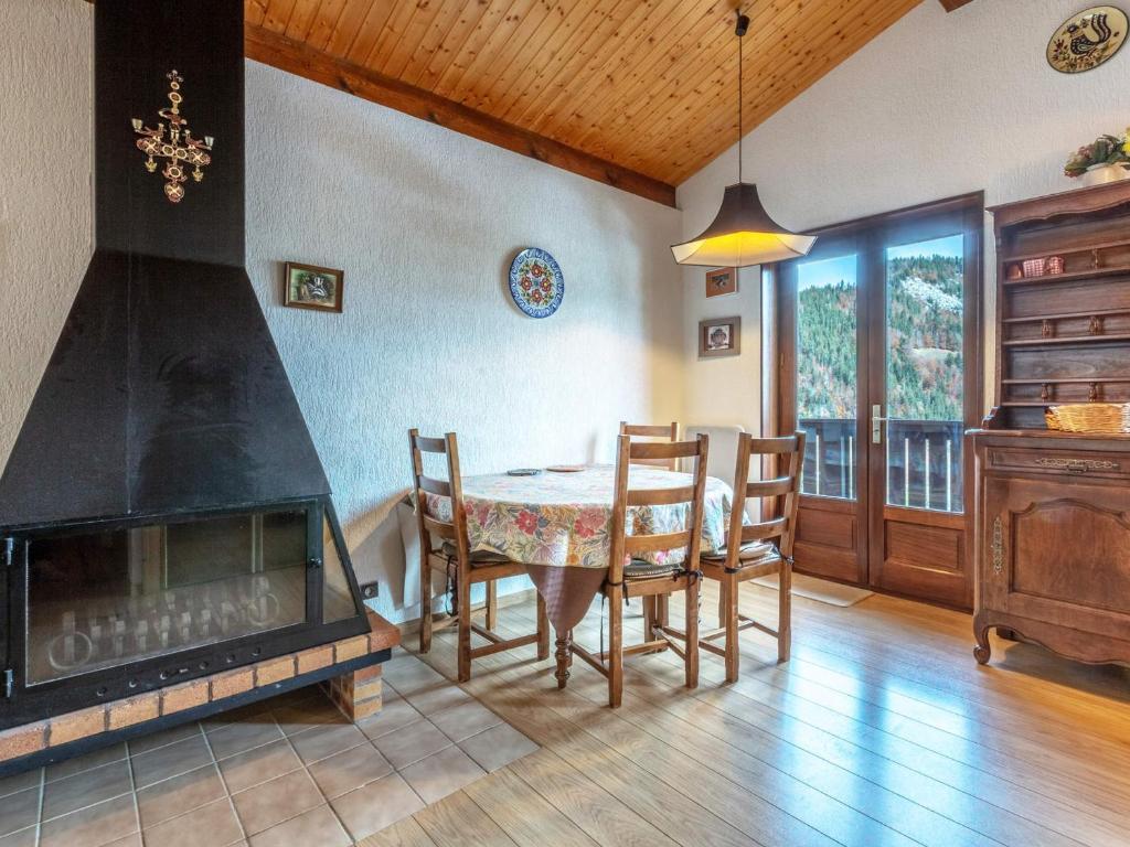 a dining room with a fireplace and a table and chairs at Appartement La Clusaz, 3 pièces, 6 personnes - FR-1-437-44 in La Clusaz